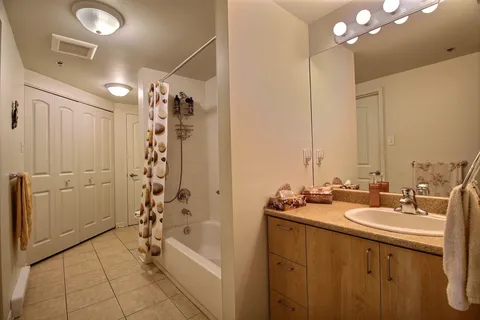 Bathroom with a bath, sink and wood cabinets.