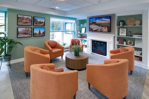 Lounge with orange armchairs and a fireplace