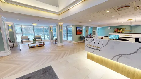 Reception desk beside windows and lounge seating