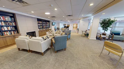 Library seating beside bookshelves and large windows