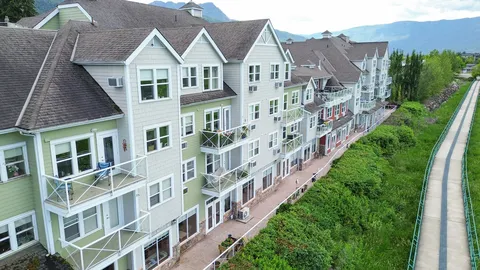 Residence building with balconies beside landscaped grounds.