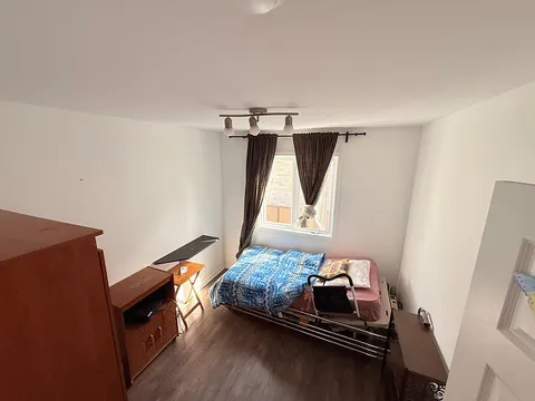 Bedroom with an adjustable bed, window, wardrobe and over-bed table.