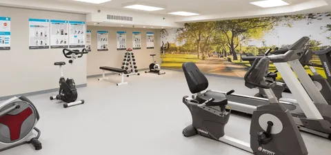 Fitness room with exercise bikes, treadmills and strength equipment.