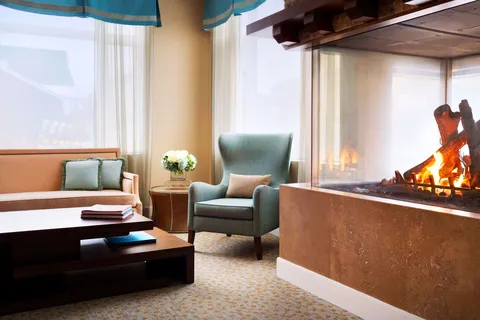 Sofa and armchair beside a glass fireplace