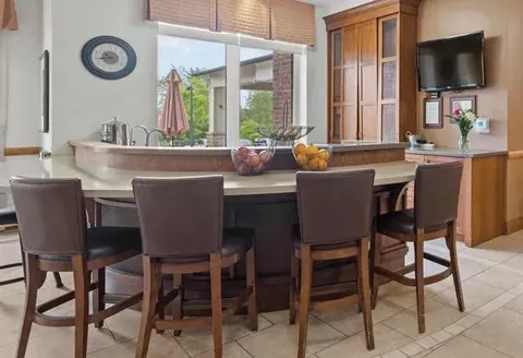 Bistro counter and stools beside large windows.
