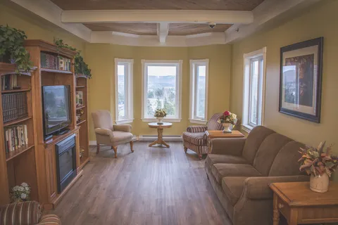 Room with sofas, armchairs, book shelves and a television