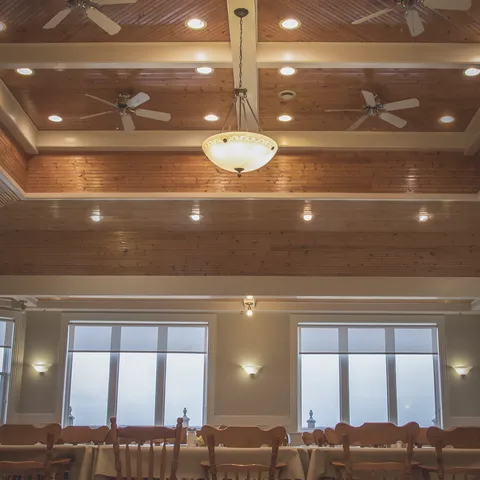Tables and chairs beneath a high wood-panelled ceiling