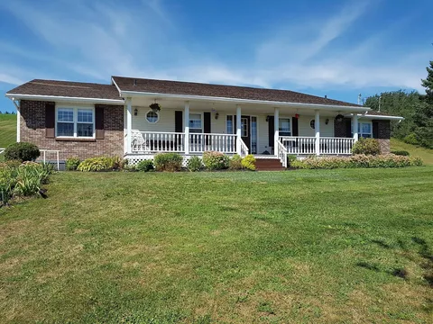 Single-storey brick and white house with a covered porch, front lawn and flower beds