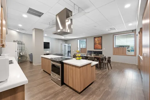 Kitchen with an island, stainless steel range, dining table and a fireplace
