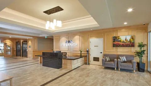Reception lobby with a counter, armchairs and wood-panelled walls