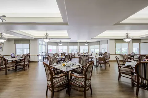 Dining room with tables, striped upholstered chairs and wide windows
