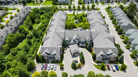 Aerial view of a grey-roofed residence around a landscaped courtyard and covered entrance