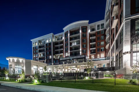 Residence building and landscaped courtyard illuminated at night.