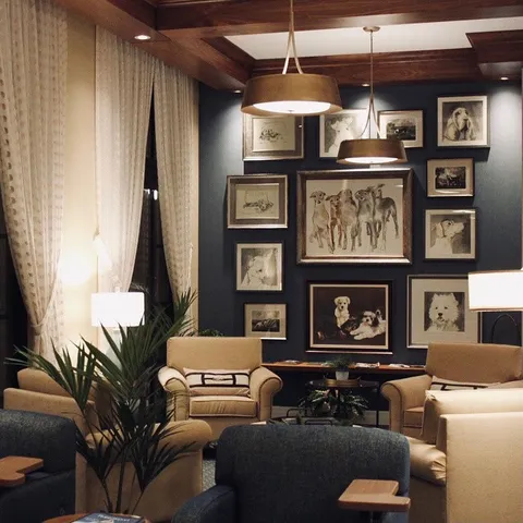 Lounge with upholstered chairs and framed dog artwork.