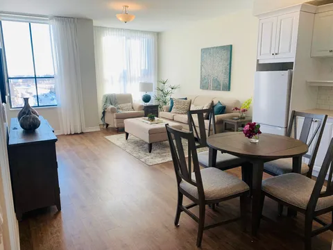 Suite living area with a sofa, dining table and kitchenette.