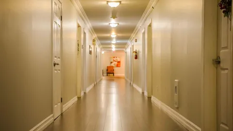 Interior corridor with chairs and rooms along each side.