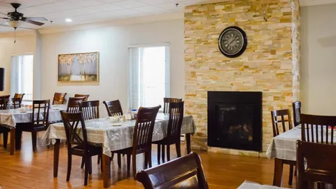 Dining area with wooden tables and a stone fireplace.