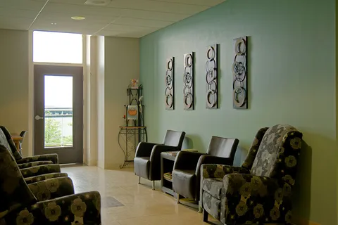 Sitting area with patterned armchairs, leather chairs and a glass door