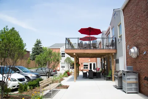 Side of the residence with a raised patio and covered walkway.
