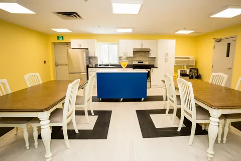 Dining tables beside a communal kitchenette.