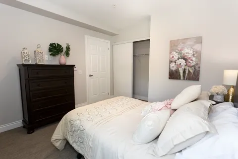 Bedroom with a bed, dresser and bedside table.