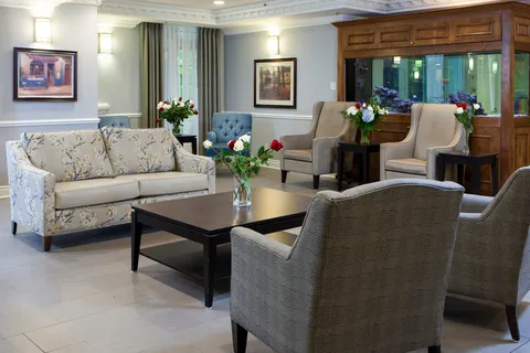 Lobby lounge with upholstered sofas, armchairs and a reception counter.