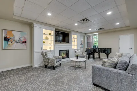Sitting area with a sofa, armchairs, a fireplace and piano