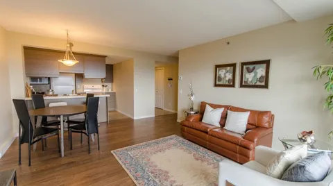 Apartment with an orange sofa, dining table and kitchen
