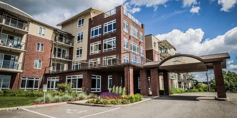 Multi-storey residence with balconies, landscaped beds and a covered entrance