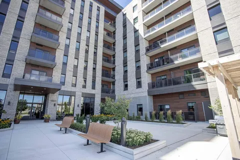 Residence building overlooking a courtyard with benches and planters