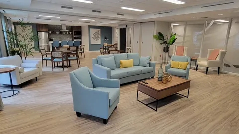 Room with blue seating, tables and a kitchen counter
