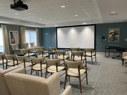 Room with chairs facing a blank projection screen