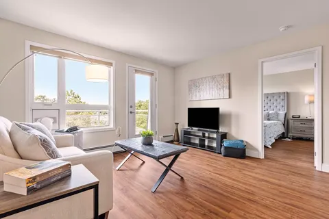 Sitting area with a sofa, television and an open bedroom doorway