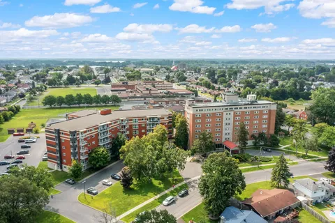 Aerial view of connected brick residence buildings beside trees and lawns