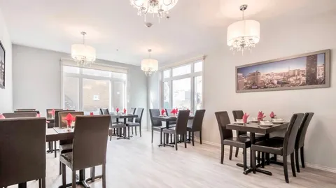 Dining room with dark chairs, square tables and pendant lamps