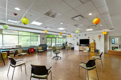 Room with tables, chairs and a wall-mounted television
