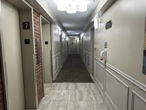 Interior hallway with suite doors and handrails.