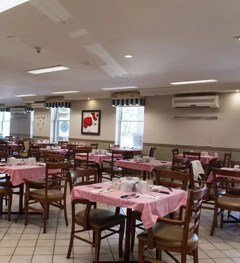 Dining room with pink tablecloths, chairs and windows