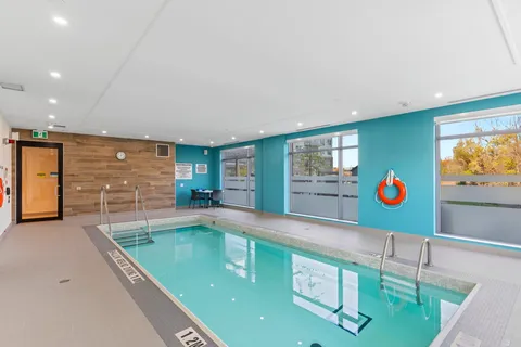Indoor swimming pool with windows and a pool lift.