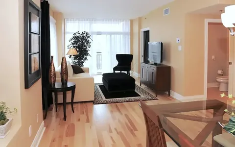 Suite living area with upholstered chair and television.