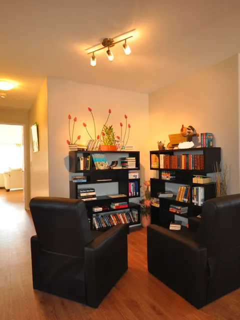 Library nook with bookshelves and two armchairs.