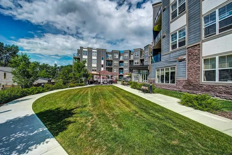 Residence building beside a curved walking path and lawn.