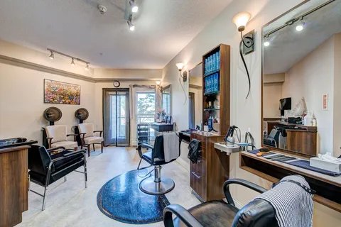 Hair salon with styling chairs, mirrors and a wash basin.