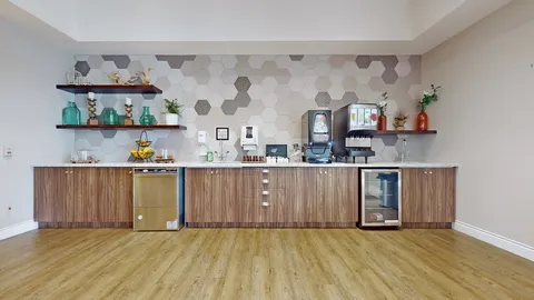 Refreshment counter with a coffee dispenser and cupboards