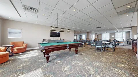 Room with a billiards table, dining tables and chairs