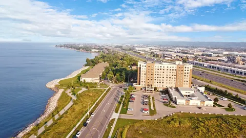 Aerial view of the residence beside a lakeside road and parking area