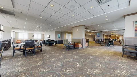 Tables and chairs in a wide room beside windows