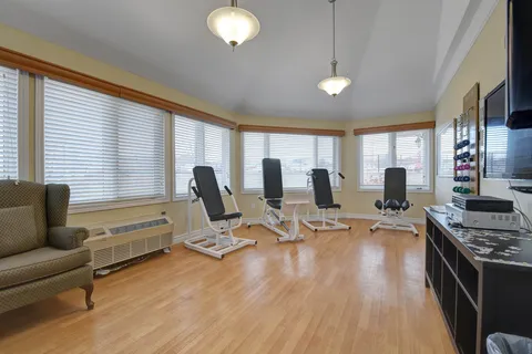 Exercise room with seated fitness equipment and large windows
