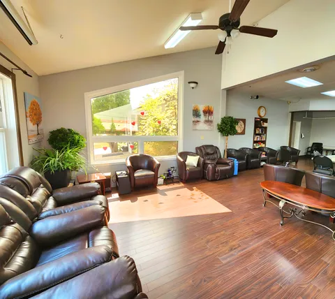 Sitting area with dark leather armchairs, tables and windows