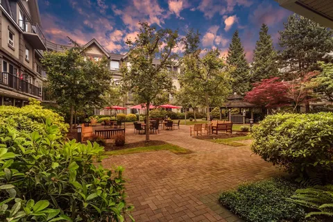 Residence building overlooking a landscaped courtyard with patio tables